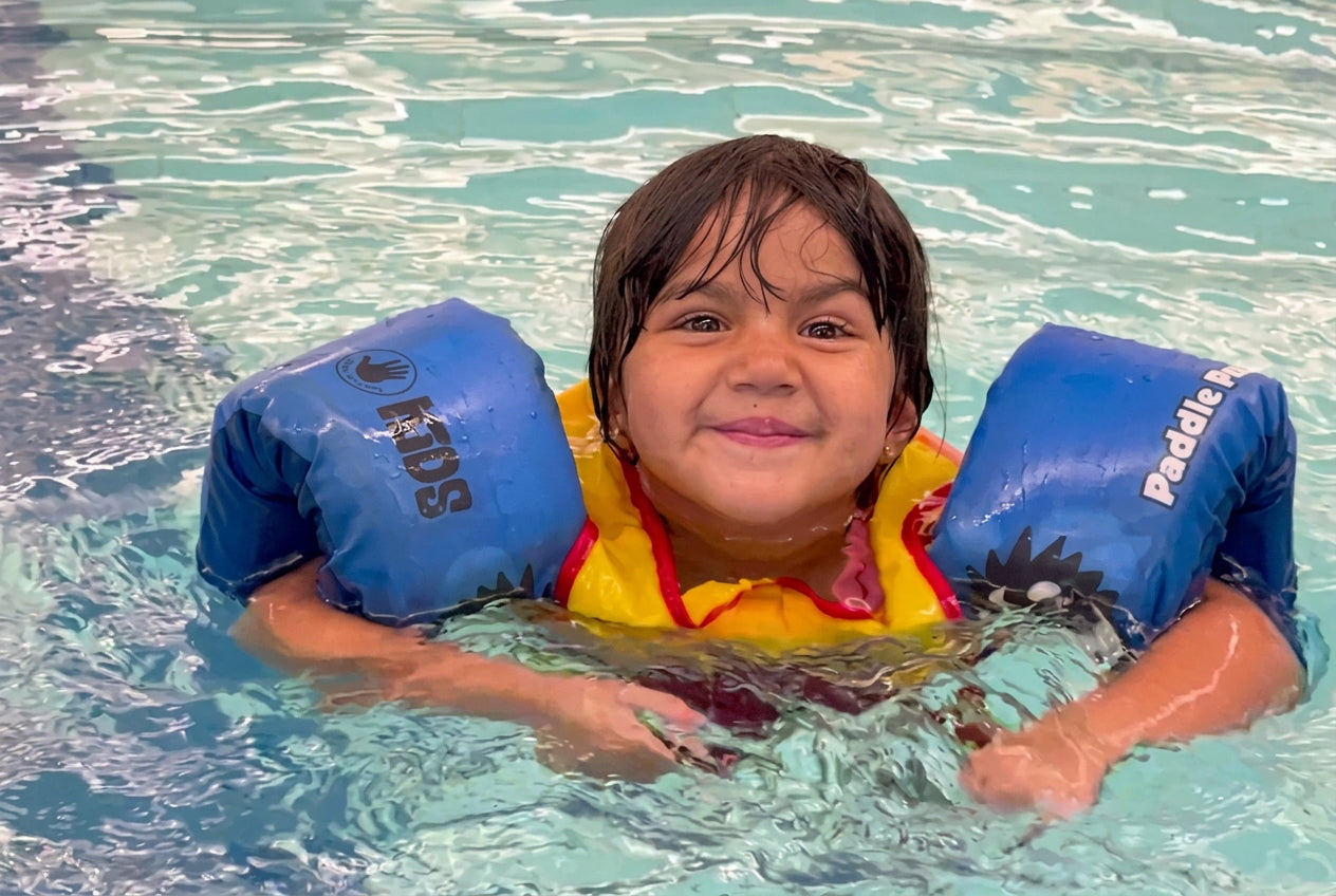 Child swimming in a puddle jumper flotation device